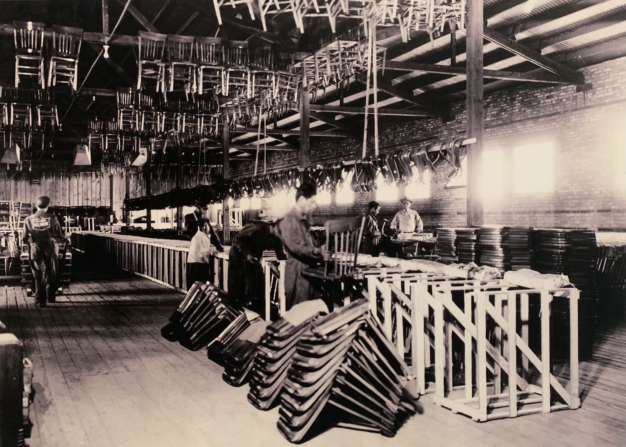personas trabajando en la línea de producción en el interior de la antigua fábrica de muebles malinche
