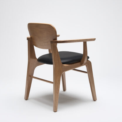 silla minimalista de madera con descansabrazos y con asiento tapizado en piel color negro vista desde atrás