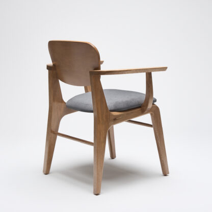 silla contemporanea de madera con descansabrazos y con asiento tapizado en tela color gris oxford vista desde atrás