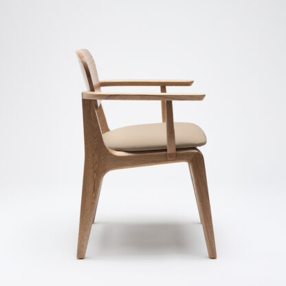 silla malinche de madera con descansabrazos y con asiento tapizado en piel color taupe vista desde un lado